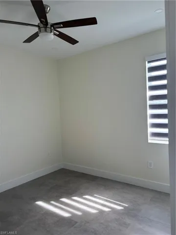 Empty room featuring baseboards and ceiling fan
