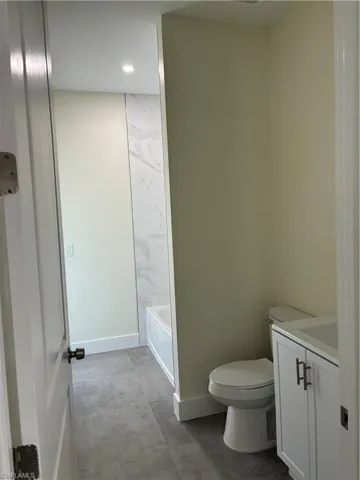 Full bath with vanity, recessed lighting, and concrete floors