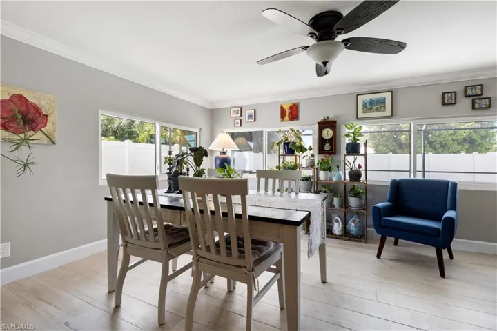 Dining space with light hardwood / wood-style porcelin tile.  Crown molding throughout the home!