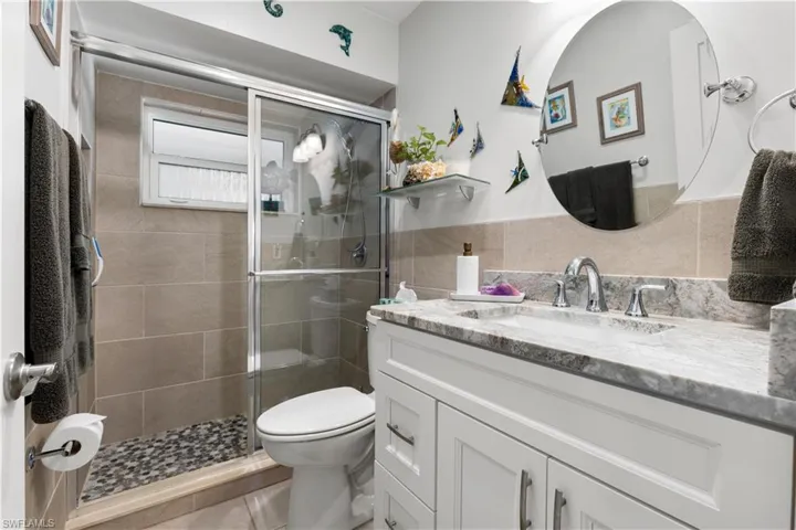 2nd Bathroom featuring glass door walk in tiled shower and beautiful granite vanity.