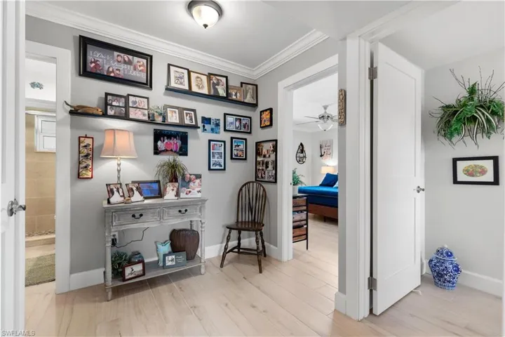Corridor featuring ornamental molding between bedrooms.