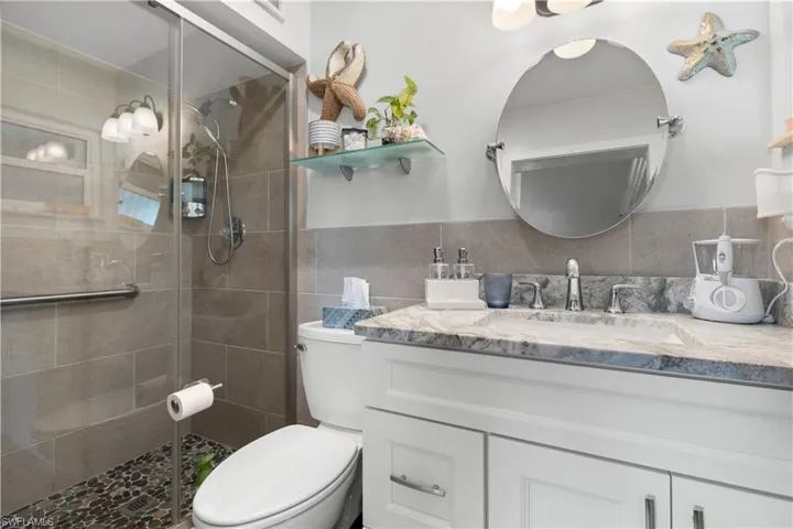 Primary Bathroom with tiled walk in shower and glass shower door.