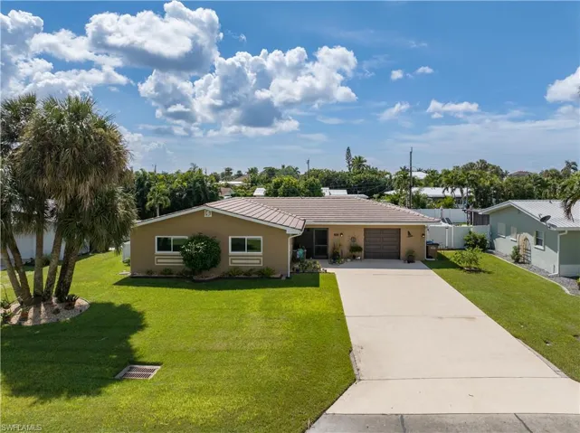 Front view of large driveway and irrigated, well maintained yard.