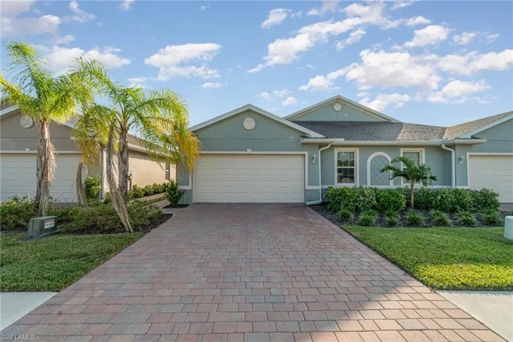 Single story home featuring a garage and a front lawn