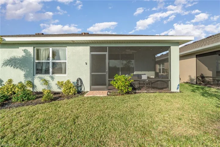 Back of property with a yard and a sunroom