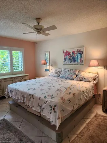 Bedroom with a textured ceiling and ceiling fan