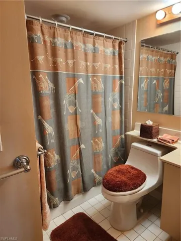 Full bath with vanity, a shower with curtain, and light tile patterned floors