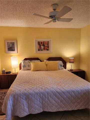 Bedroom with a textured ceiling and ceiling fan