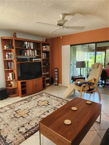 Living area with a textured ceiling and a ceiling fan