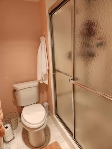Bathroom with a stall shower and light tile patterned floors