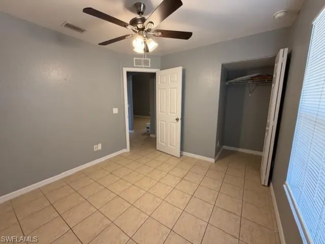 Unfurnished bedroom featuring light tile patterned floors and ceiling fan