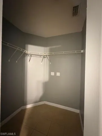 Walk in closet featuring dark tile patterned floors