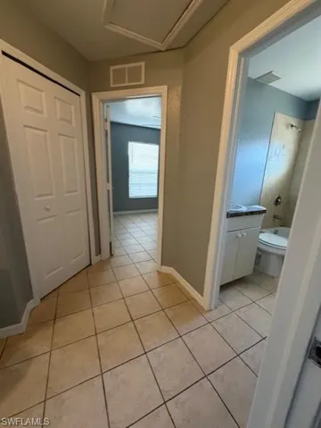Hall featuring light tile patterned flooring