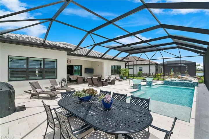 View of swimming pool with outdoor lounge area, an in ground hot tub, glass enclosure, and a patio area