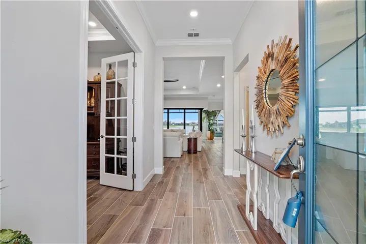 Hallway featuring light hardwood / wood-style floors, french doors, and crown molding