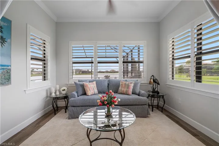 Living room with hardwood / wood-style floors, plenty of natural light, and crown molding