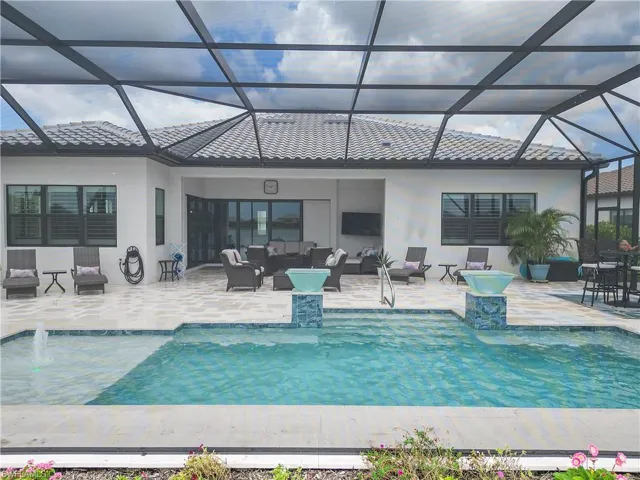 View of swimming pool featuring pool water feature, outdoor lounge area, a lanai, and a patio