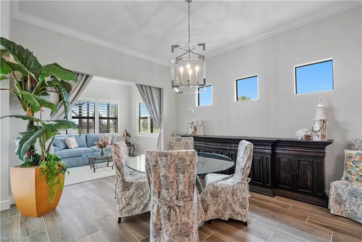 Dining space featuring crown molding, hardwood / wood-style floors, and an inviting chandelier