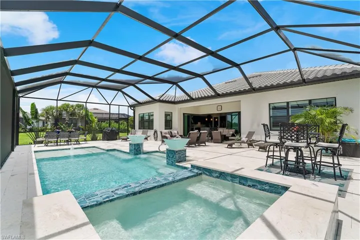 View of swimming pool with a patio area, an outdoor hangout area, and glass enclosure