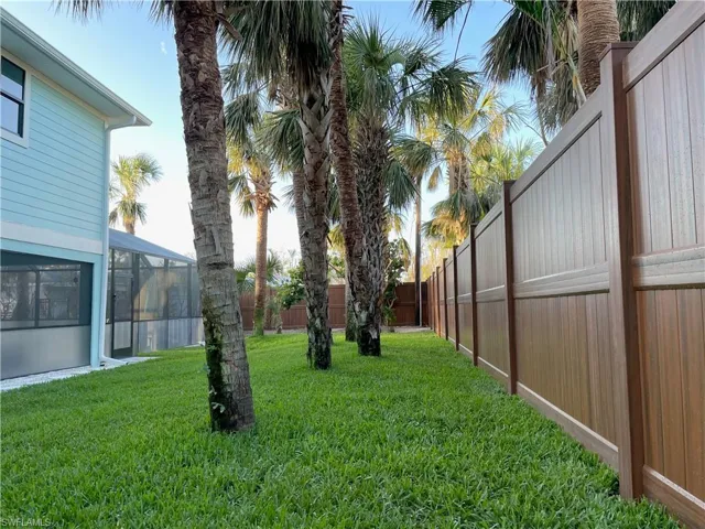 Private fenced in Back yard with multiple palms and foliage