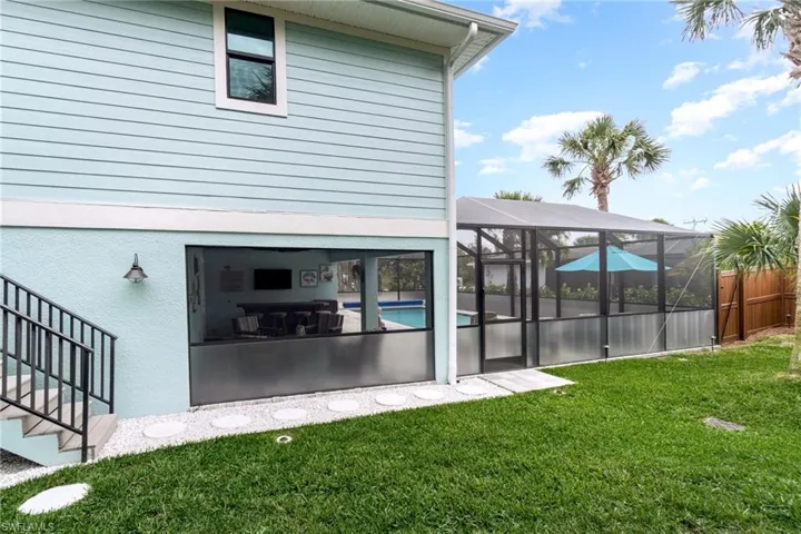 Private fenced in Back yard with multiple palms and foliage