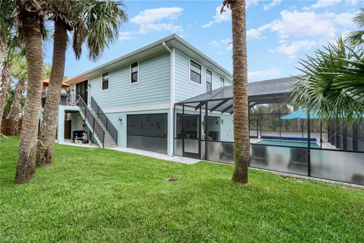 Private fenced in Back yard with multiple palms and foliage