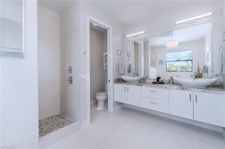 Primary en-suite bathroom with dual sinks, walk-in shower and soaking tub