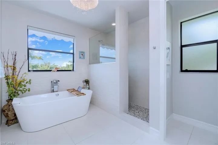 Primary en-suite bathroom with dual sinks, walk-in shower and soaking tub
