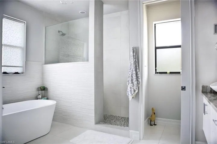 Primary en-suite bathroom with dual sinks, walk-in shower and soaking tub
