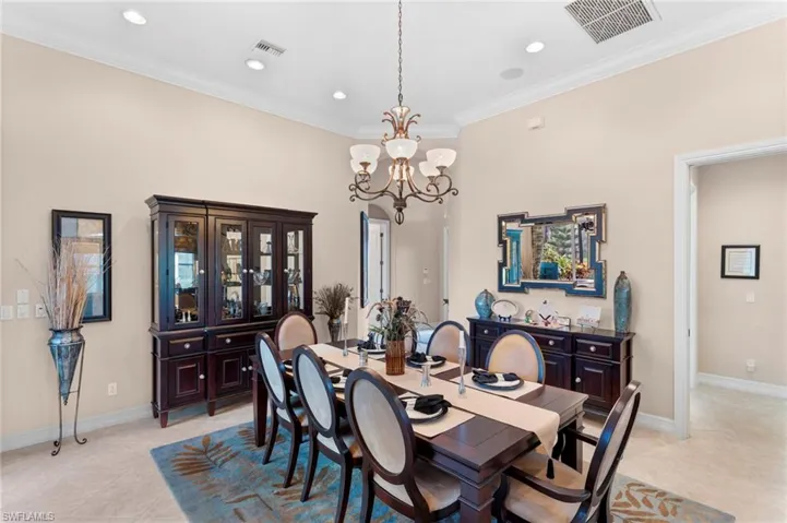 Tiled dining space with ornamental molding and a chandelier