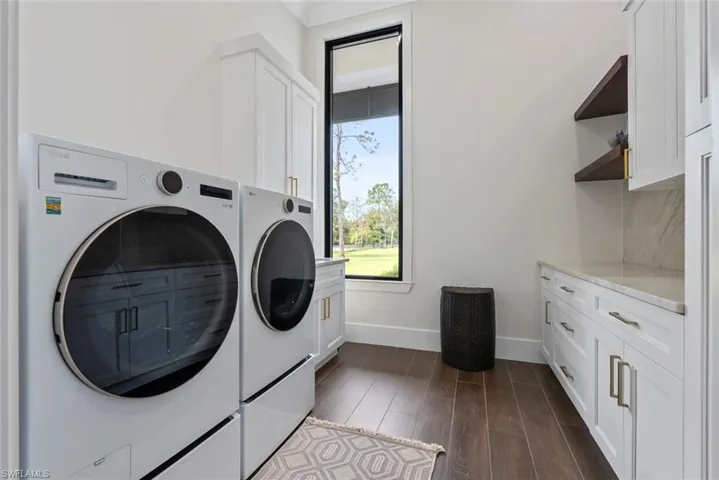 Laundry area featuring cabinets, dark wood-type flooring, and independent washer and dryer