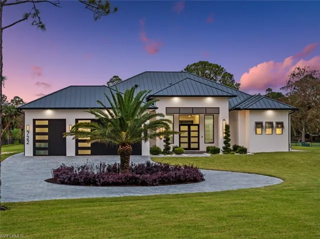 View of front facade with a garage and a yard