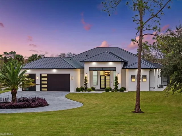 View of front facade with a garage and a lawn