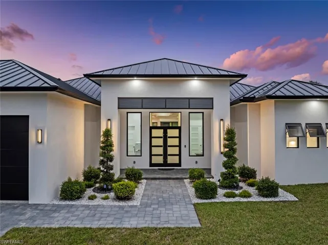 Exterior entry at dusk with a yard