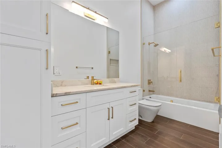 Full bathroom with vanity, bathtub / shower combination, and toilet