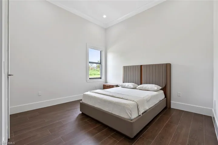 Bedroom featuring ornamental molding and dark hardwood / wood-style flooring