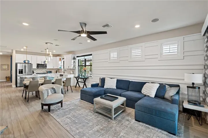 Living room with ceiling fan and light hardwood / wood-style floors