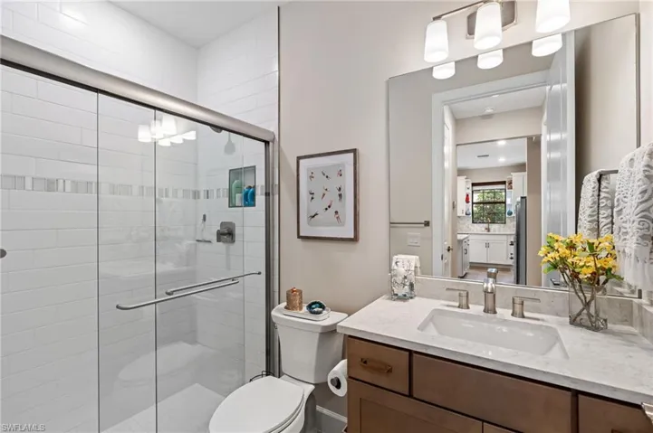 Bathroom with walk in shower, vanity, and toilet
