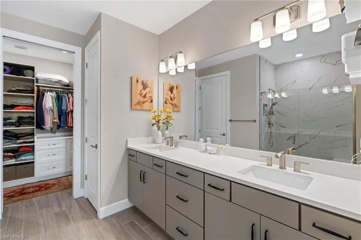 Bathroom featuring a shower with door and vanity
