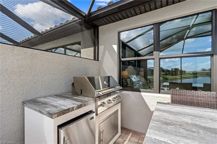 View of patio / terrace featuring a water view, an outdoor kitchen, and a grill