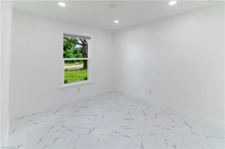 Unfurnished room with light marble finish flooring and recessed lighting
