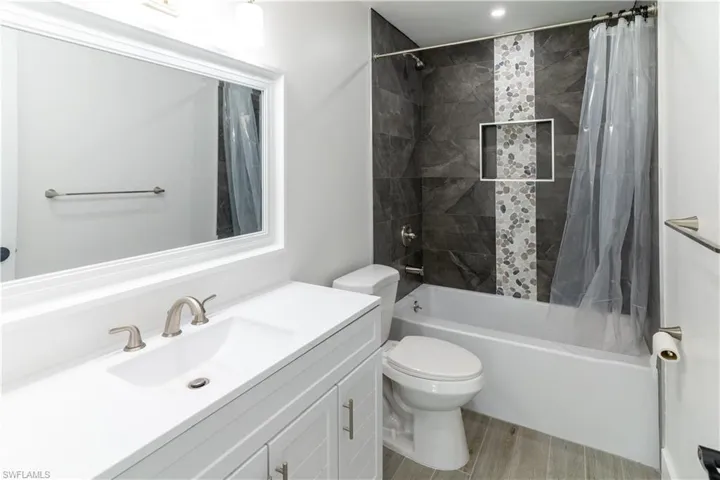 Bathroom featuring shower / bath combo, vanity, and light wood finished floors