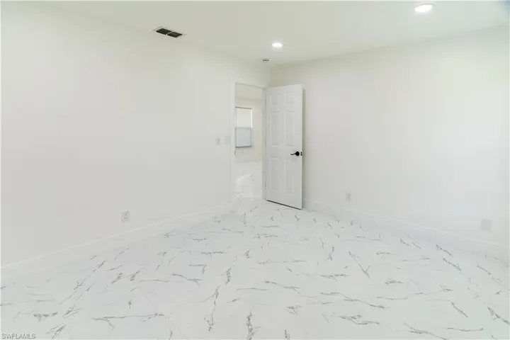 Unfurnished room with recessed lighting and light marble finish flooring