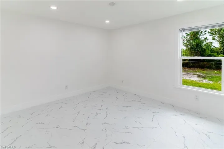 Empty room featuring recessed lighting and light marble finish flooring