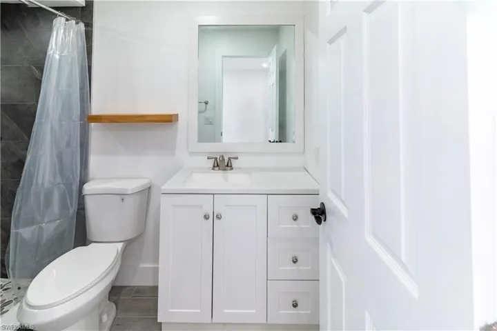 Bathroom with vanity, a stall shower, and wood finished floors