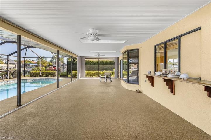 Huge under truss patio area with sliders to all home areas/pass thru window and granite bar and accordion hurricane shutters to enclose as needed to extended living space