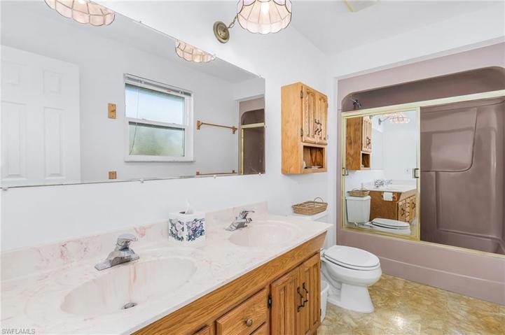 Upstairs bath with dual sinks and tub and shower and impact window/also in hallway another walkin closet and pull down stairs to attic