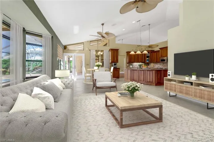 Living room featuring high vaulted ceiling, light tile patterned floors, and ceiling fan