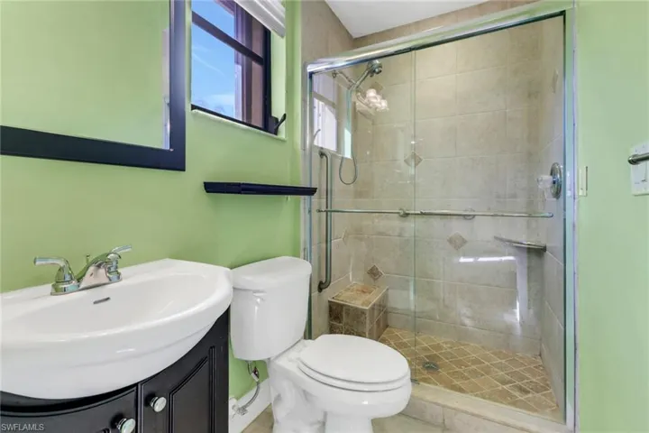 Bathroom with an enclosed shower, vanity, and toilet