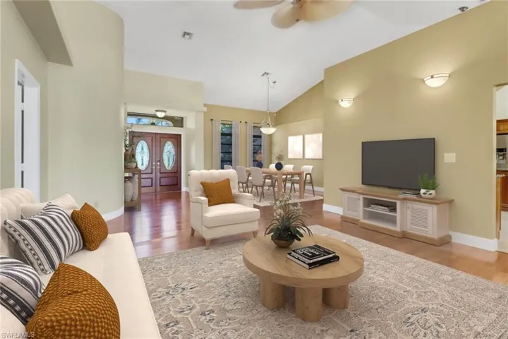 Living room featuring high vaulted ceiling, hardwood / wood-style flooring, and ceiling fan